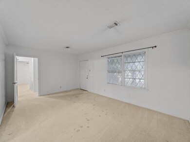 Living room with ornamental molding, light carpet,
