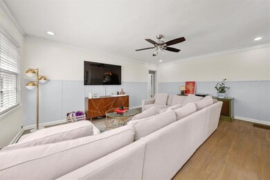 Living area featuring a ceiling fan, wainscoting, light wood flooring, ornamental molding, and recessed lighting