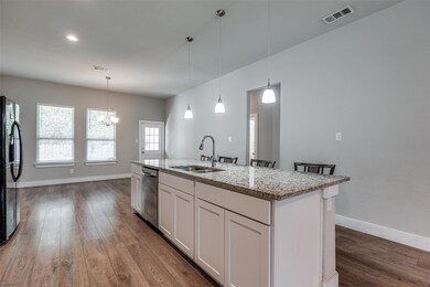 Kitchen featuring a center island with sink, white