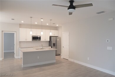 Kitchen with visible vents, white cabinets, applia