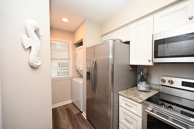 Kitchen with stacked washer / drying machine, dark