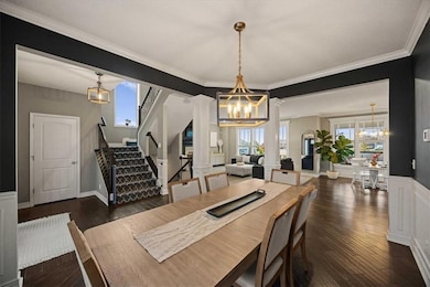 Dining space with ornate columns, a chandelier, stairs, healthy amount of natural light, and ornamental molding