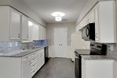 Kitchen featuring white cabinetry, electric stove,