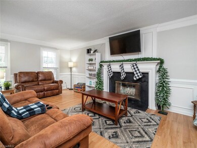 Living room with fireplace crown molding and great natural light.
