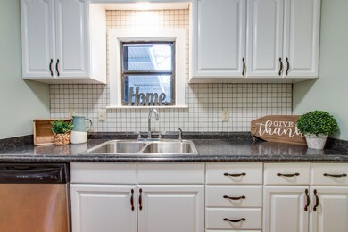 Window over the sink looks out onto the back wooded lot..