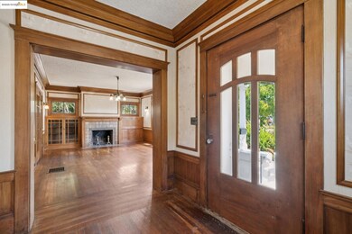 Foyer with crown molding, a textured ceiling, dark wood finished floors, plenty of natural light, and a chandelier