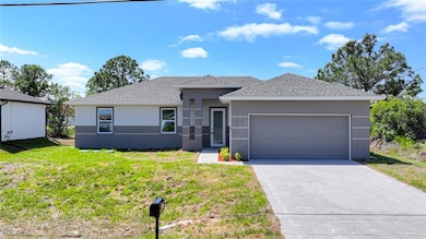 Prairie-style house featuring stucco siding, decorative driveway, a front yard, and a shingled roof