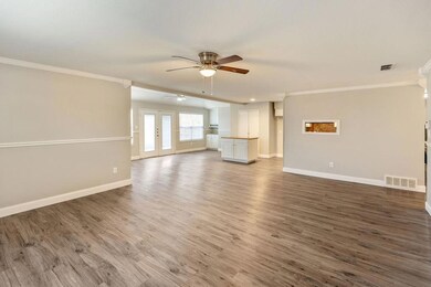 Unfurnished living room with visible vents, wood f