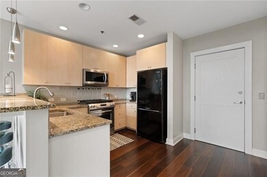 Kitchen featuring appliances with stainless steel finishes, light brown cabinets, a peninsula, light stone countertops, and recessed lighting