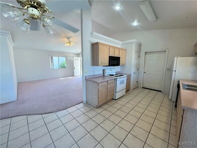 Kitchen featuring vaulted ceiling, white appliance