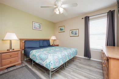 Bedroom with light wood finished floors, baseboar