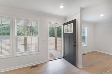 Foyer featuring wood finished floors, baseboards,