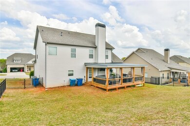 Rear view of house with a shingled roof, a yard, a