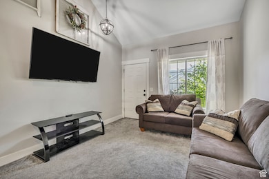 Living room featuring lofted ceiling and carpet