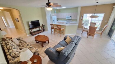 Living room with arched walkways, a ceiling fan, and light tile patterned floors