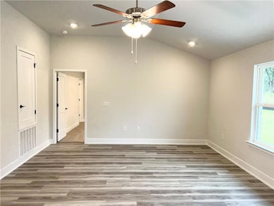Spare room with vaulted ceiling, wood finished floors, ceiling fan, and recessed lighting