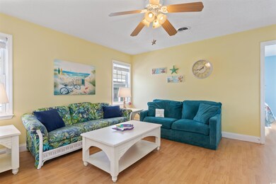 Living area featuring visible vents, a ceiling fan
