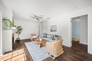 Living room featuring ornamental molding, dark wo