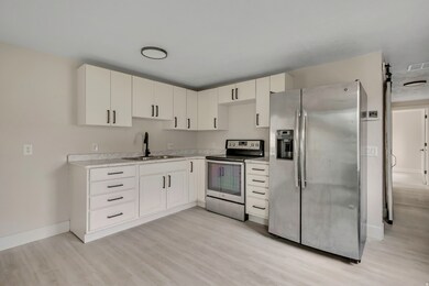Kitchen with appliances with stainless steel finishes, light countertops, and white cabinets