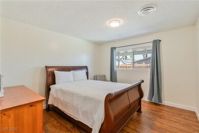 Bedroom featuring dark wood-type flooring, a textu