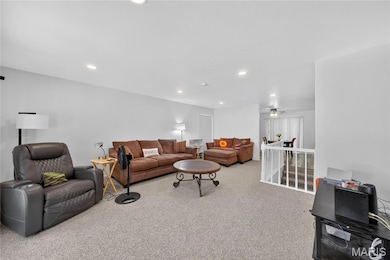 Living area featuring light colored carpet and recessed lighting
