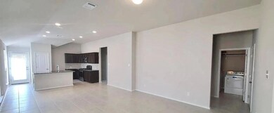 Kitchen with washer / dryer, an island with sink,