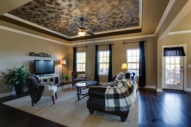 The Family Room is open to the Kitchen/Breakfast Area, and features hardwood flooring with a carpet inlay, a trey ceiling with faux finish accent, crown molding, and overlooks the back yard and deck area. 