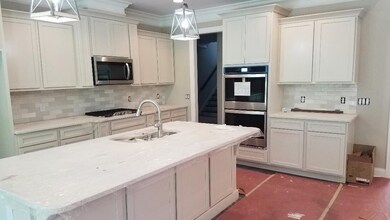 Elegant kitchen with huge island - island has working cabinets on both sides. Double ovens, gas cooktop; even the micro is vented out!  Sand and finish hardwoods here, too.  QUARTZ counters throughout.