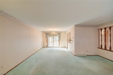 Empty room with a chandelier and light carpet