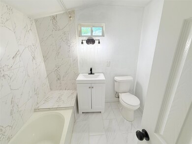 Full bathroom with marble finish floor, toilet, an
