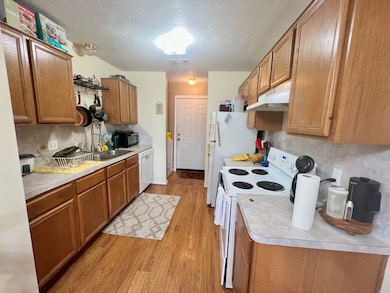 Kitchen featuring under cabinet range hood, brown