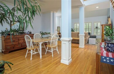 Dining area featuring ornate columns, light hardwo