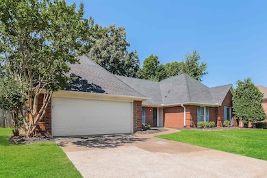 View of front of home with a garage and a front ya