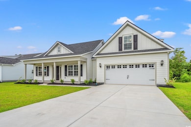 View of front of property with board and batten siding, driveway, a front yard, a garage, and a shingled roof