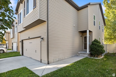 View of home's exterior with an attached garage, a yard, and driveway