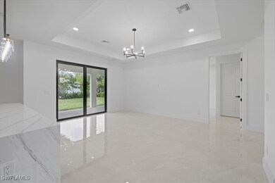Empty room with a chandelier, a tray ceiling, ligh