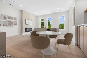 Dining room featuring a glass covered fireplace, recessed lighting, radiator heating unit, and light wood-style floors