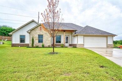 View of front facade with a garage and a front law