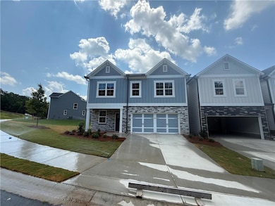View of front of property with stone siding, concrete driveway, a garage, and a front yard