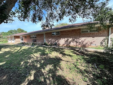 Rear view of property with crawl space, brick siding, and a lawn