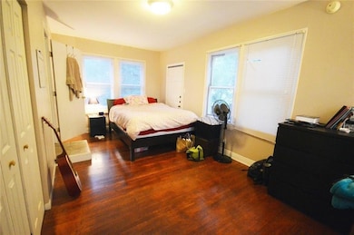 Bedroom featuring dark wood-style flooring and baseboards