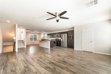 Unfurnished living room featuring a ceiling fan, w