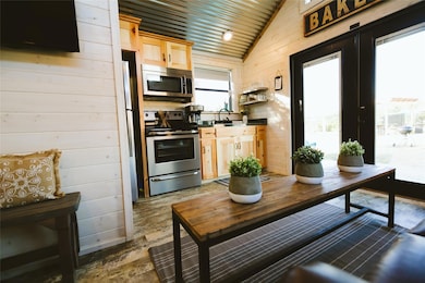 Kitchen featuring vaulted ceiling, wood walls, a 