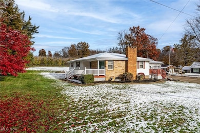 View of front of home with a chimney, a lawn, and stone siding