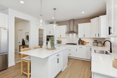 (Photo of decorated model, actual homes finishes will vary) The stunning gourmet kitchen features a large center island, quartz countertops, LVP floors, stainless appliances and more!