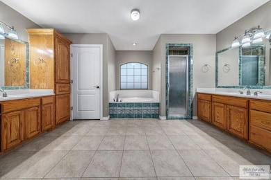 Bathroom featuring shower with separate bathtub, tile patterned flooring, and vanity