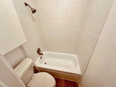 Bathroom with shower / tub combination and wood f