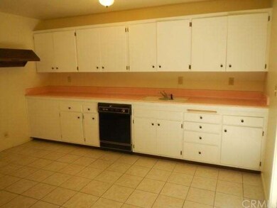 Newly painted kitchen with tiled counter tops, new knobs, new lighting, dishwasher, garbage disposal, tiled floor, original Rangemate hood and fan