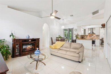 Living room featuring arched walkways, a glass cov