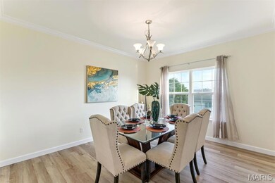 Dining room featuring crown molding, light wood-type flooring, and a chandelier
